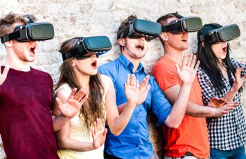 Surprised friends exploring metaverse on vr glasses – Virtual reality and wearable tech concept with happy people having fun together with headset goggles – Digital generation trends on bright filter